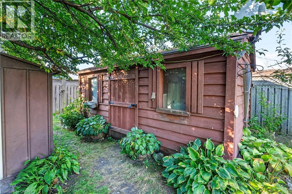 Shed structure featuring wood siding, a window, and a wood door - 215 Paling Avenue, Hamilton, ON