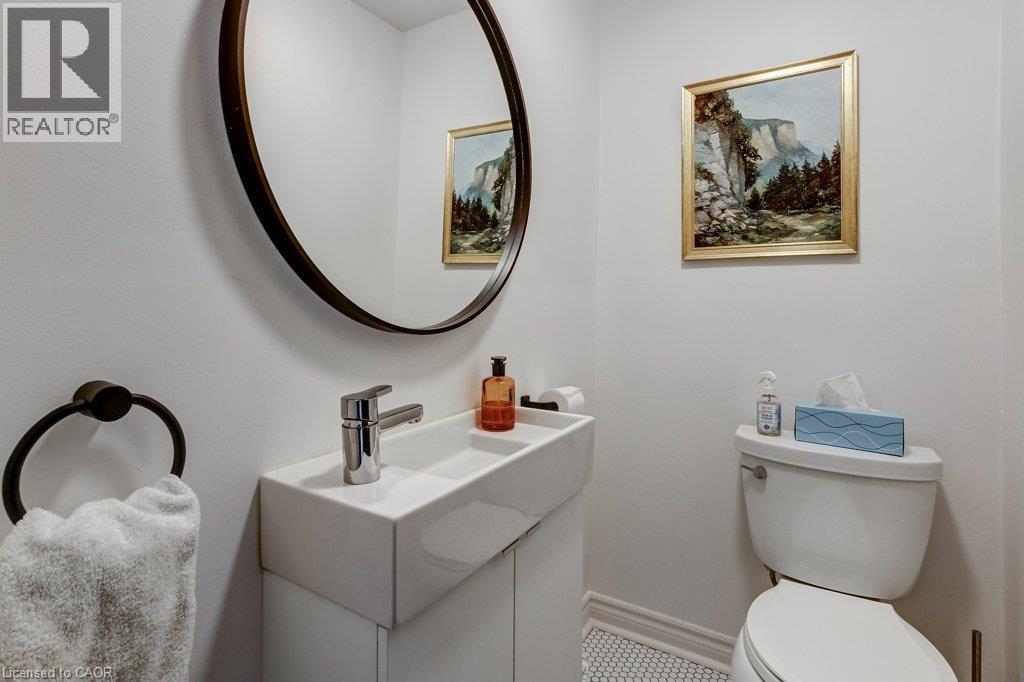 White ceramic toilet and wall-mounted sink with chrome faucet - 43 Rosslyn Avenue S, Hamilton, ON