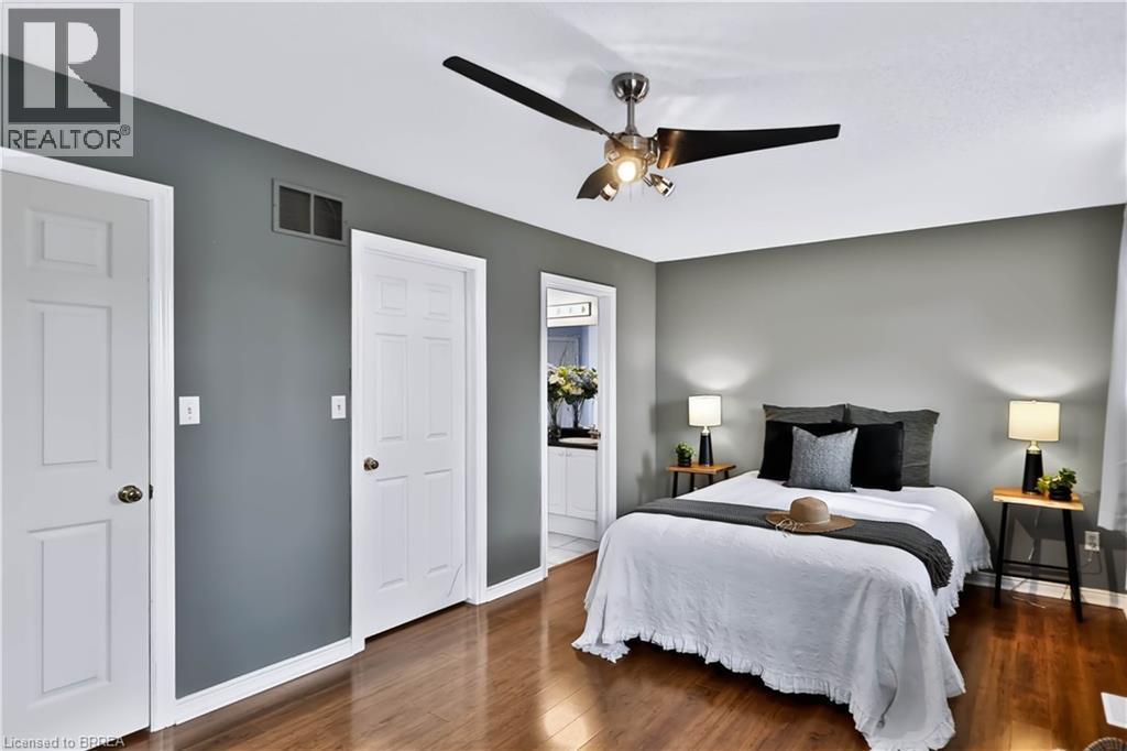 Wood-finish flooring, neutral grey walls, white trim, and a ceiling fan with integrated lighting - 19 Hyslop Drive, Caledonia, ON