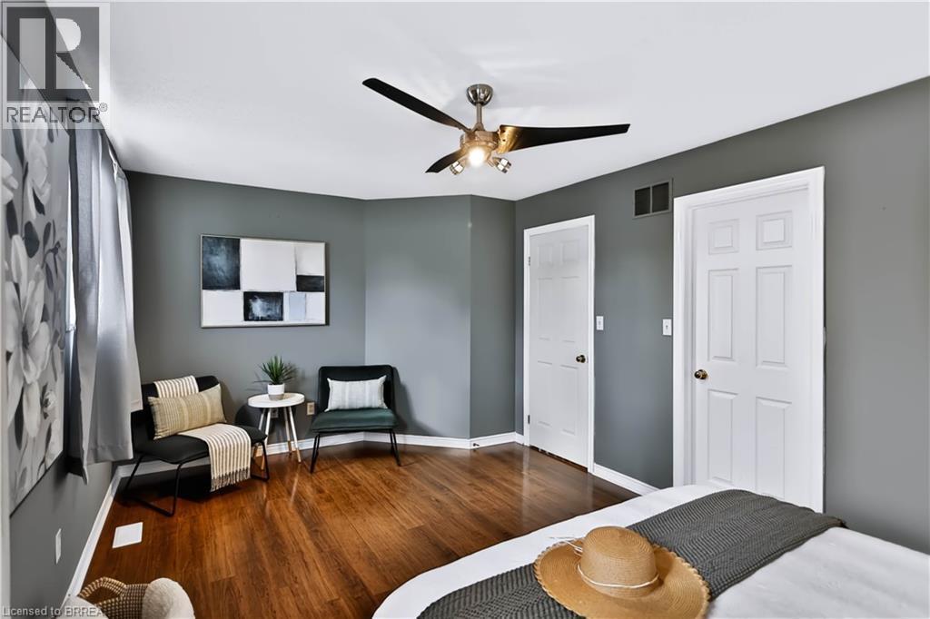 Wood-finish flooring, ceiling fan with integrated lighting, and multiple paneled doors - 19 Hyslop Drive, Caledonia, ON