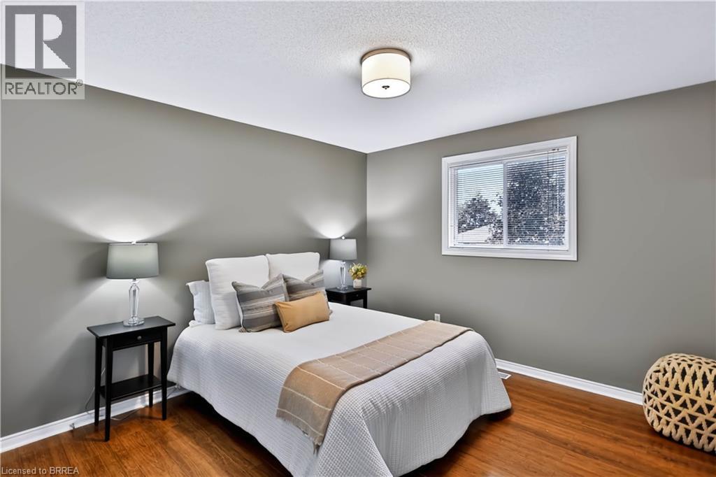 Hardwood-finish flooring, neutral wall paint, and a white ceiling with a flush-mount light fixture - 19 Hyslop Drive, Caledonia, ON