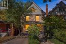 Two-story residence featuring a covered front porch with white railings, a front-facing gable. - 98 Sanford Avenue S, Hamilton, ON 
