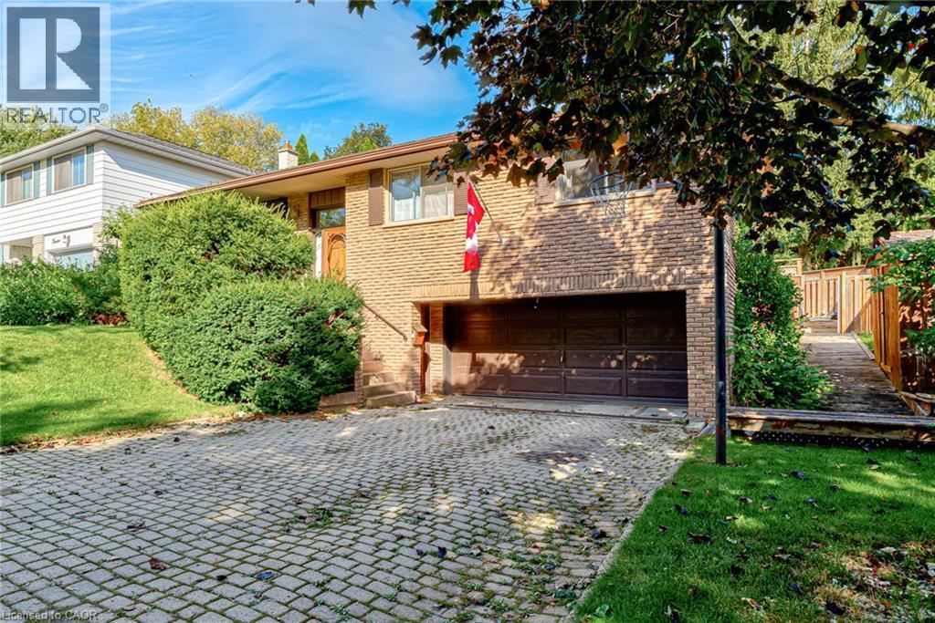 Brick exterior with an integrated garage, block paving driveway, and mature landscaping - 8 Bonnylyn Drive, Kitchener, ON