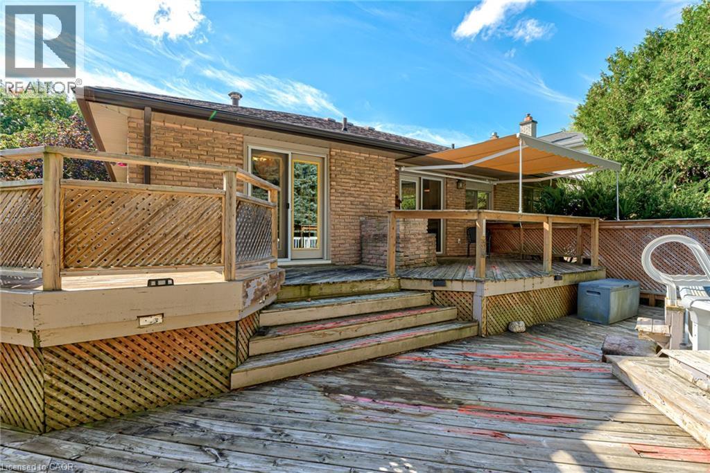 Multi-level wood deck with lattice skirting, brick exterior, and sliding glass doors - 8 Bonnylyn Drive, Kitchener, ON