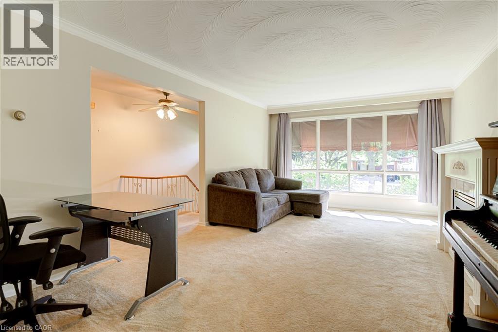 Spacious room featuring broad windows, crown molding, and a built-in fireplace - 8 Bonnylyn Drive, Kitchener, ON