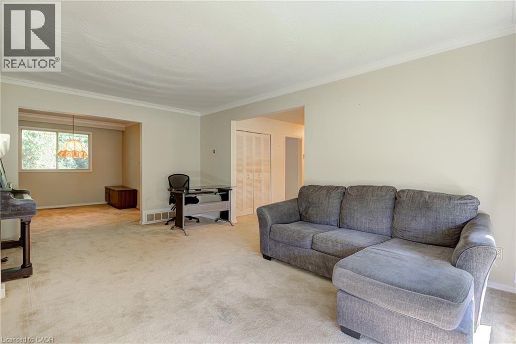 Carpeted flooring, neutral wall tones, white trim, and a window with a hanging light fixture - 8 Bonnylyn Drive, Kitchener, ON
