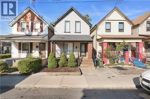 Two-story residential structure featuring light-colored siding and a dark roof - 73 Clinton Street, Hamilton, ON 