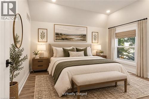 Vaulted ceiling, wood-finish flooring, recessed lighting, and a large window with natural light - 73 Clinton Street, Hamilton, ON 