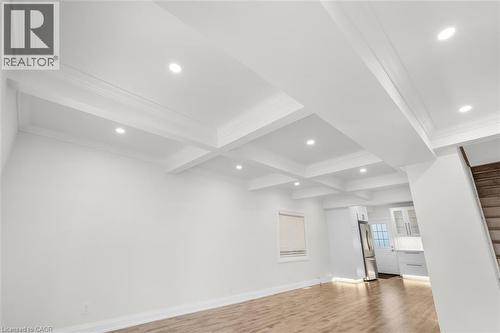 Coffered ceiling with recessed lighting, wood-finish flooring, white walls, and a window with blinds - 73 Clinton Street, Hamilton, ON 