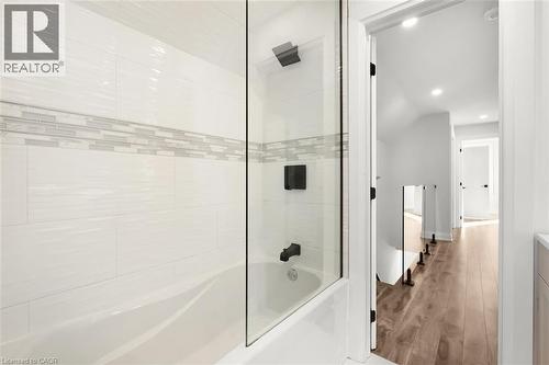Bathtub with a glass shower panel and matte black fixtures - 73 Clinton Street, Hamilton, ON 