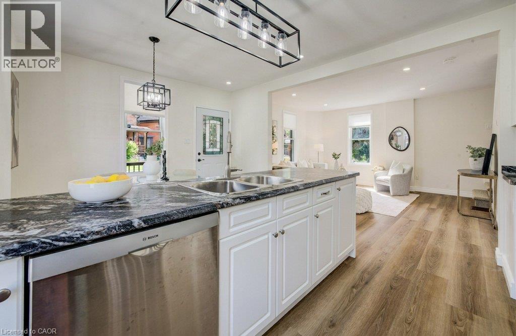 Kitchen island featuring a double basin sink, stainless steel dishwasher, and dark patterned countertop - 185 Strange Street, Kitchener, ON - Indoor Photo Showing Kitchen With Double Sink With Upgraded Kitchen