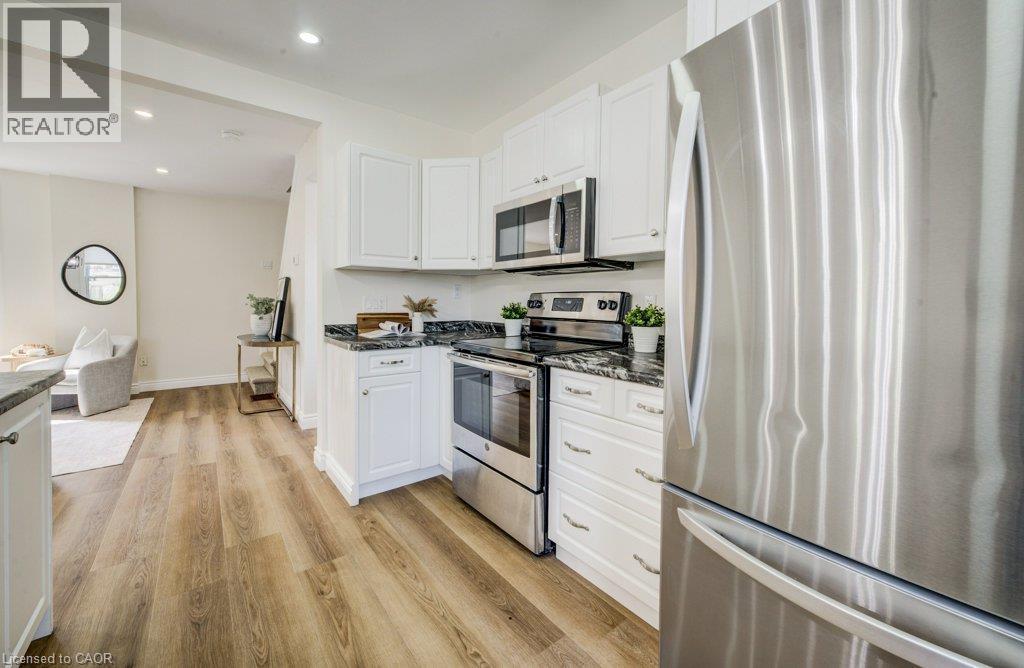 White cabinetry and dark stone countertops - 185 Strange Street, Kitchener, ON - Indoor Photo Showing Kitchen With Upgraded Kitchen