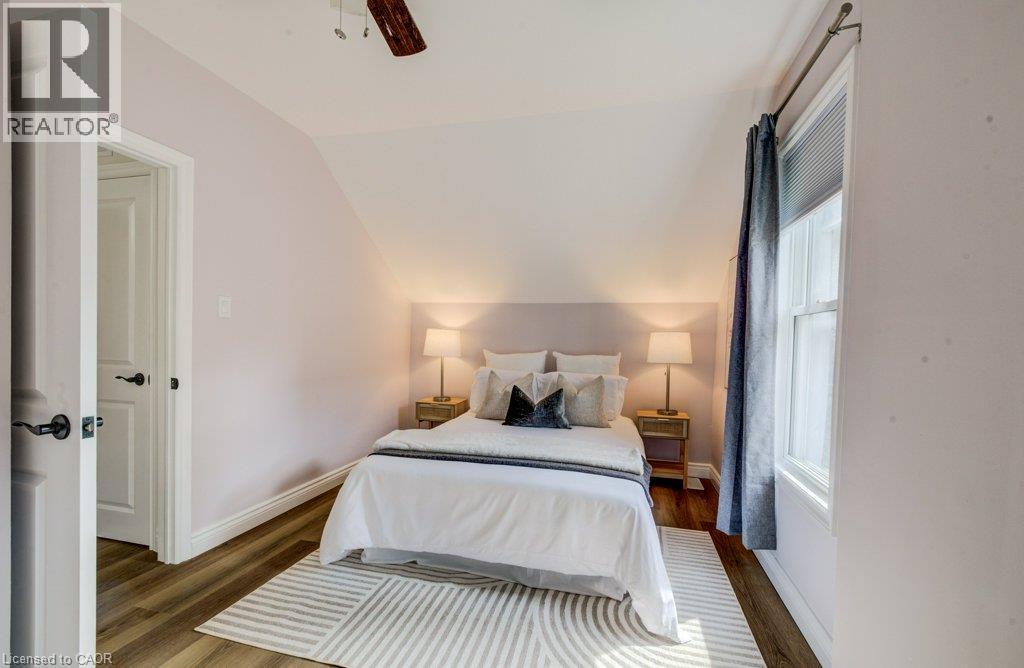 Vaulted ceiling featuring a ceiling fan, wood-finish flooring, and white trim - 185 Strange Street, Kitchener, ON - Indoor Photo Showing Bedroom