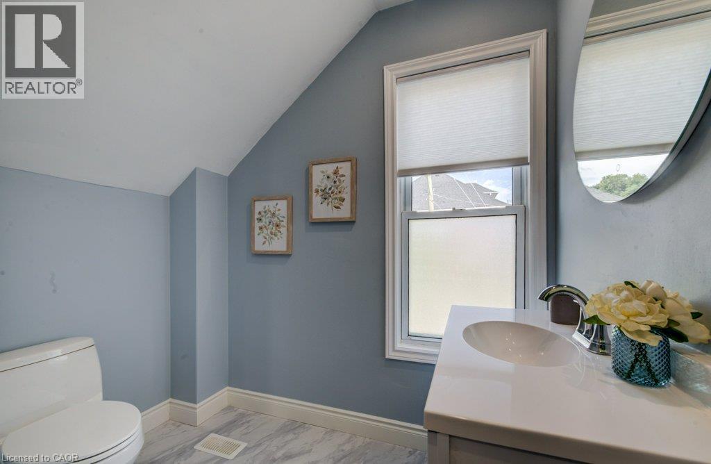 Sloped ceiling accentuates the vanity with an integrated sink and chrome faucet - 185 Strange Street, Kitchener, ON - Indoor Photo Showing Bathroom