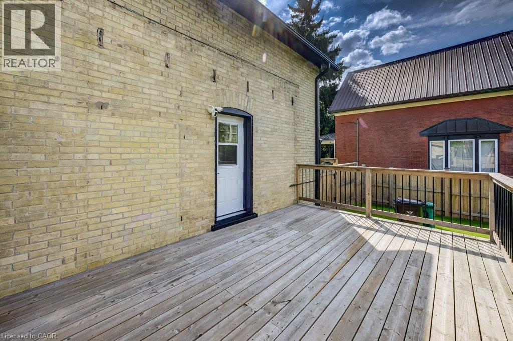 Expansive outdoor deck featuring wood decking and a wood railing with black balusters - 185 Strange Street, Kitchener, ON - Outdoor With Deck Patio Veranda With Exterior