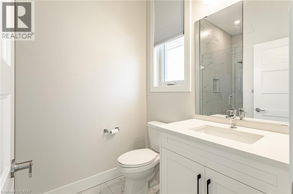 White shaker-style vanity with a light-toned countertop and an integrated rectangular sink - 7966 Fallon Drive Unit# 18, Lucan Biddulph (Twp), ON - Indoor Photo Showing Bathroom