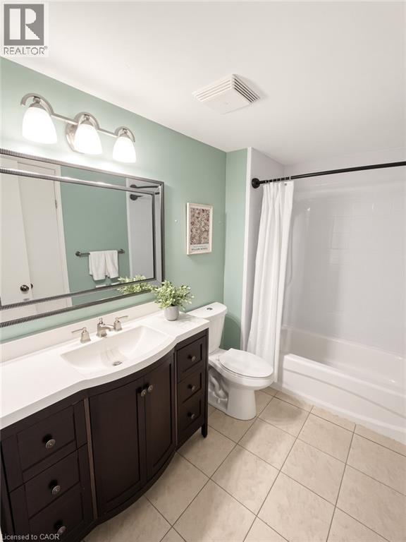 Dark wood-finish vanity with an integrated sink, white countertop, and tiled flooring - 765 Angler Way, Waterloo, ON - Indoor Photo Showing Bathroom