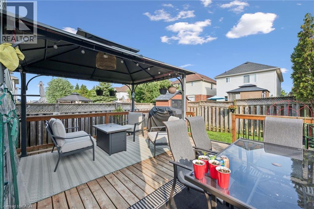 Outdoor deck featuring a dark metal gazebo, wood fencing, and a manicured lawn - 765 Angler Way, Waterloo, ON - Outdoor With Deck Patio Veranda With Exterior