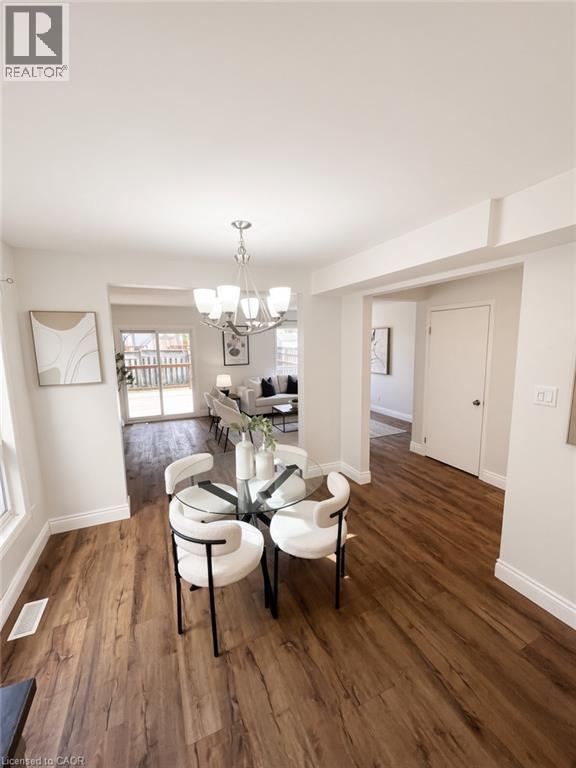 Wood-finish flooring throughout, bright white walls, recessed ceiling, modern chandelier, and sliding glass patio doors - 765 Angler Way, Waterloo, ON - Indoor