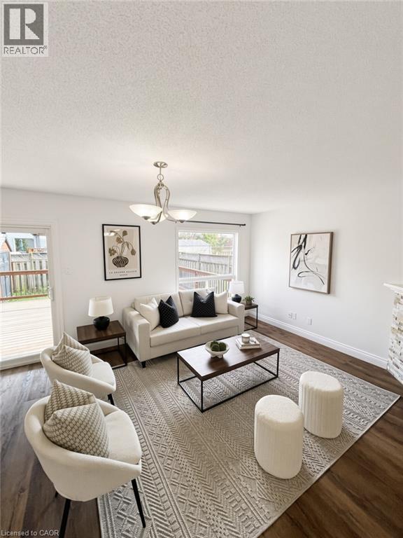 Wood-finish flooring, white walls, and a multi-light fixture - 765 Angler Way, Waterloo, ON - Indoor Photo Showing Living Room