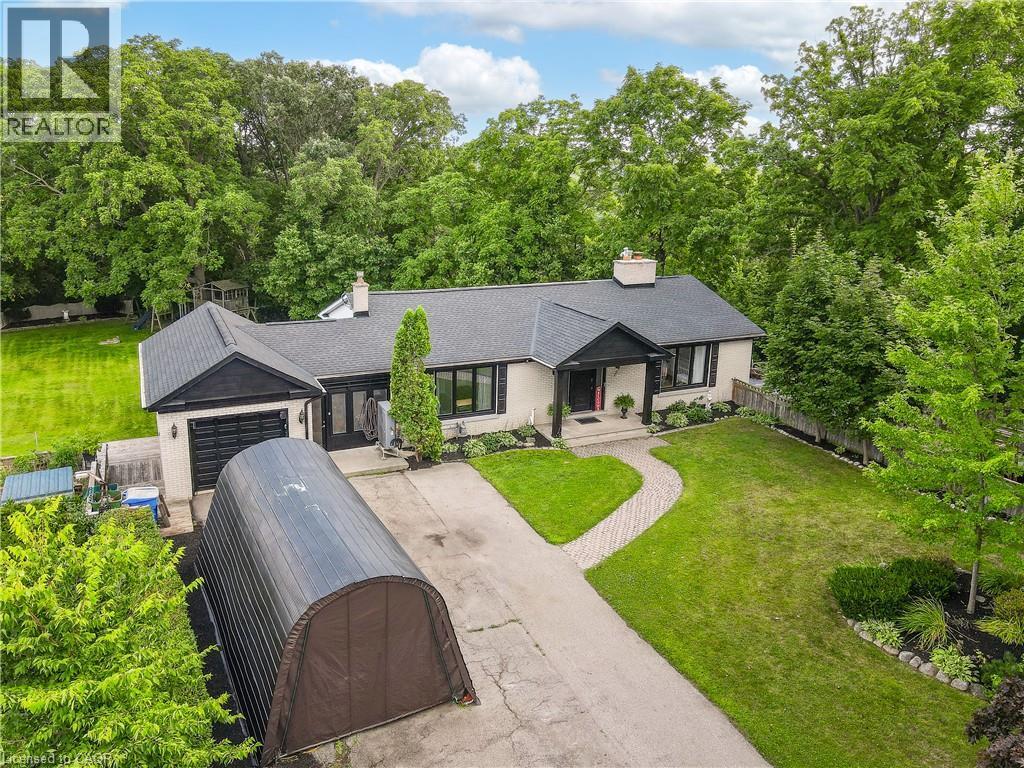 Exterior with a light-colored facade, black-trimmed windows, a dark roof, an attached garage, and a paved driveway - 267 Abraham Street, Cambridge, ON - Outdoor