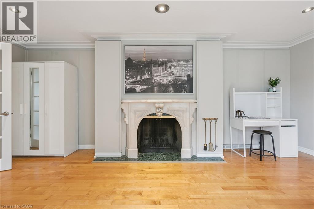 Hardwood flooring, recessed ceiling lighting, crown molding, marble fireplace surround, and French doors - 267 Abraham Street, Cambridge, ON - Indoor Photo Showing Living Room With Fireplace