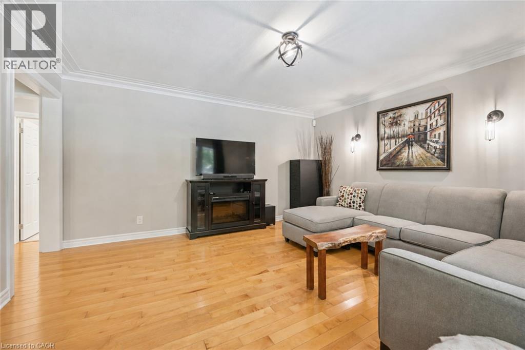 Hardwood flooring, crown molding, recessed lighting, wall sconces, and an electric fireplace - 267 Abraham Street, Cambridge, ON - Indoor Photo Showing Living Room