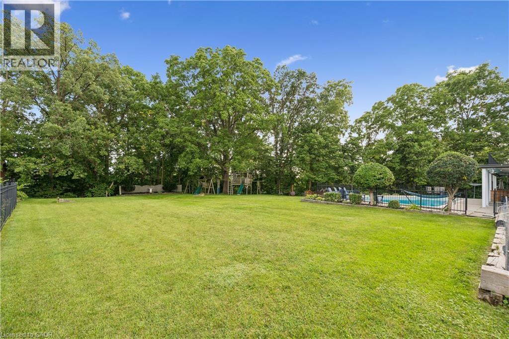 Expansive lawn area with a fenced-in swimming pool and mature trees - 267 Abraham Street, Cambridge, ON - Outdoor