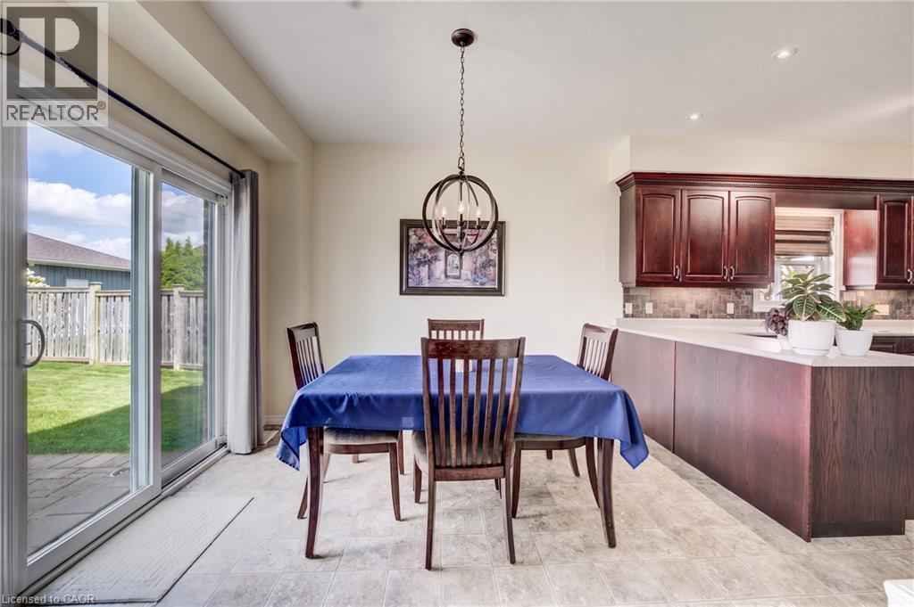 Sliding glass patio door, Linoleum flooring, dark wood cabinetry, light countertops, and a circular pendant light fixture - 64 Kropf Drive, Baden, ON - Indoor Photo Showing Dining Room