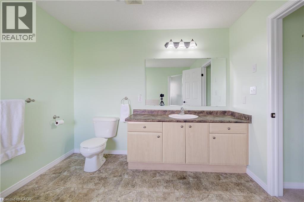 Spacious bathroom featuring a single vanity with under-sink storage, a solid surface countertop, a sink, and an overhead vanity light - 64 Kropf Drive, Baden, ON - Indoor Photo Showing Bathroom