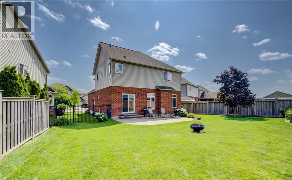 Expansive green lawn with a mature tree, bordered by wood fencing - 64 Kropf Drive, Baden, ON - Outdoor With Backyard With Exterior