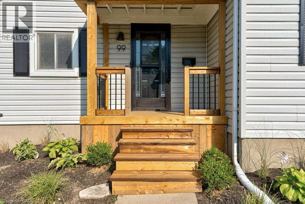 Front entry with natural wood porch and steps, black framed screen door, and white siding - 99 Shantz Lane, Kitchener, ON - Outdoor With Exterior