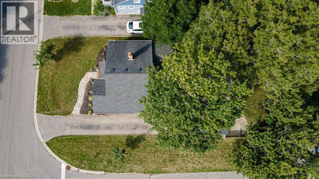 Asphalt shingle roof, stone pathway, landscaped garden beds, green lawn, and mature trees - 99 Shantz Lane, Kitchener, ON - Outdoor