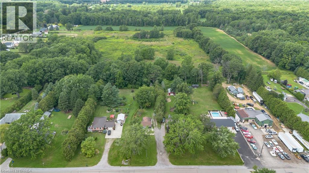 Aerial perspective showcasing multiple residential properties surrounded by mature trees and expansive green areas - 995 Mcdowell Road E, Simcoe, ON - Outdoor With View