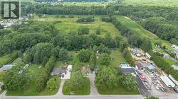 Aerial perspective showcasing multiple residential properties surrounded by mature trees and expansive green areas -