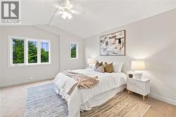 Vaulted ceiling with a ceiling fan, broad window with multiple panes, additional single-pane window, and neutral wall tones - 