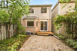 Stone patio with a wood deck, sliding glass door, and a bay window - 