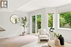Bright interior space featuring light-colored carpeting, multiple windows, a sliding glass door, and a built-in countertop - 