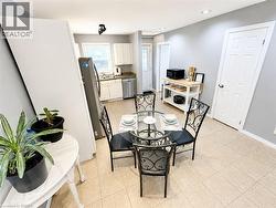 Kitchen featuring tile flooring, white cabinetry, integrated dishwasher, and recessed lighting -