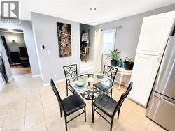 Recessed lighting, tile flooring, white cabinetry, stainless steel refrigerator, and a window with blinds -