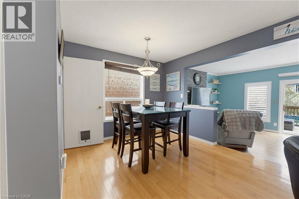 Hardwood flooring throughout, recessed ceiling with pendant lighting, and a white interior door - 592 Little Dover Crescent, Waterloo, ON - Indoor Photo Showing Dining Room
