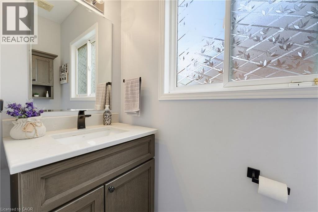 White single-basin sink with a dark bronze faucet, set into a light-toned countertop - 592 Little Dover Crescent, Waterloo, ON - Indoor Photo Showing Bathroom