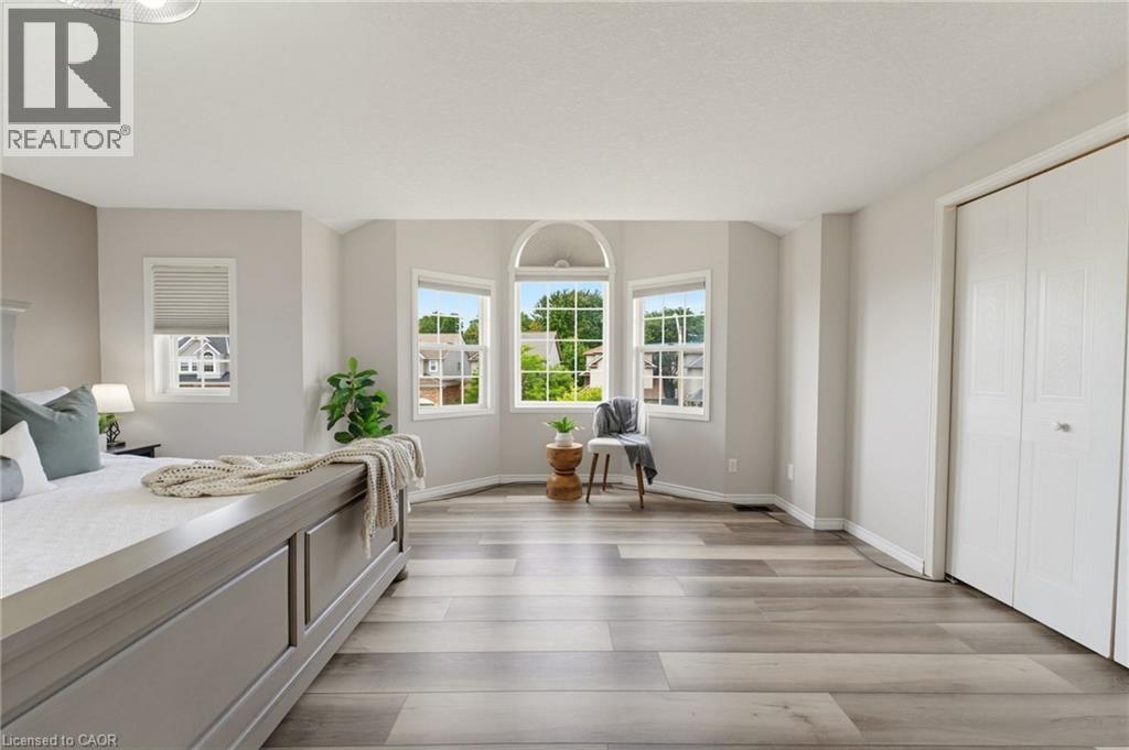 Bay window with arched transom, wood-finish flooring, and bi-fold closet doors - 592 Little Dover Crescent, Waterloo, ON - Indoor Photo Showing Other Room