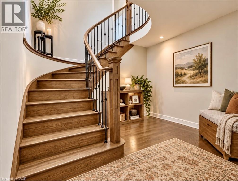 Curved staircase with wood treads and wrought iron balusters - 56 Windrush Trail, Kitchener, ON