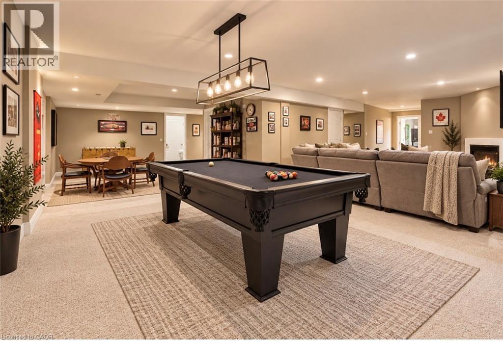 Recessed lighting, contemporary light fixture, built-in shelving, fireplace, and carpet flooring - 56 Windrush Trail, Kitchener, ON