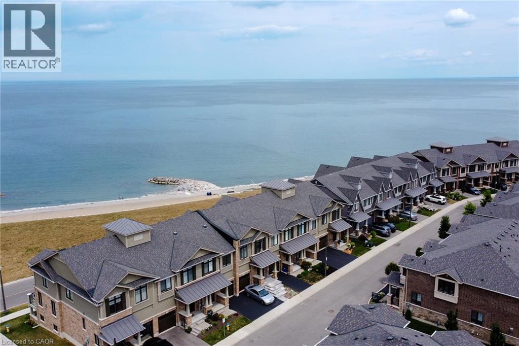 Waterfront properties featuring multi-level construction, attached garages, and paved driveways - 65 Waterview Lane, Grimsby, ON