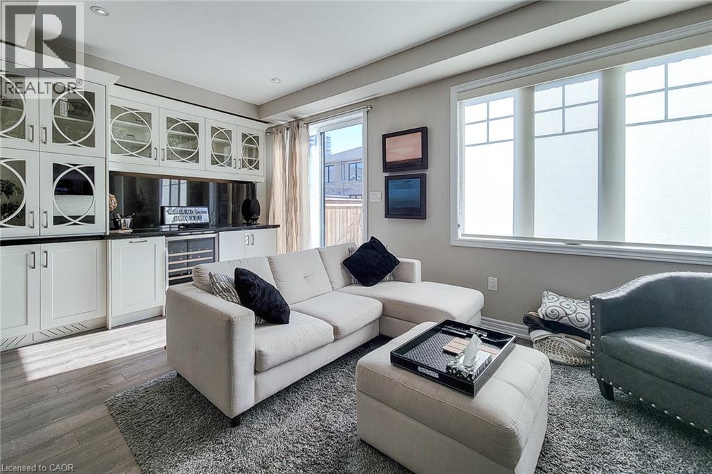 Built-in cabinetry with glass panel doors, dark countertops, recessed lighting, and wood-finish flooring - 65 Waterview Lane, Grimsby, ON