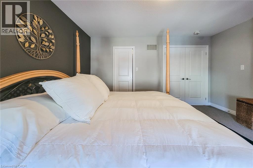 Room featuring two paneled doors, carpet flooring, and a wall-mounted vent - 65 Waterview Lane, Grimsby, ON