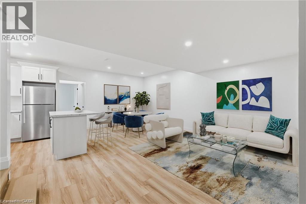 Open-concept living area with wood-finish flooring, recessed lighting, and white walls - 36 Elliott Street Unit# 1, Cambridge, ON