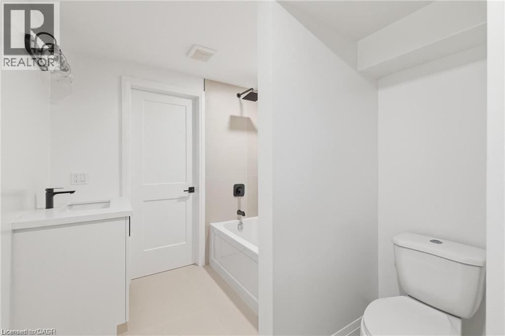 White vanity with a quartz-finish countertop and black-finish faucet - 36 Elliott Street Unit# 1, Cambridge, ON